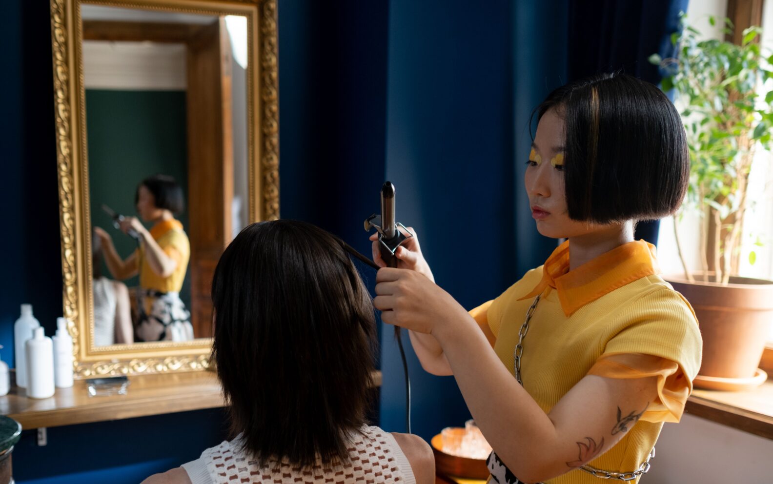 Hairstylist carrying out detailed hair styling work on a client in a professional salon